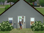A heterosexual couple kisses in front of a small, simple house.