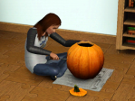 A woman carves a pumpkin.
